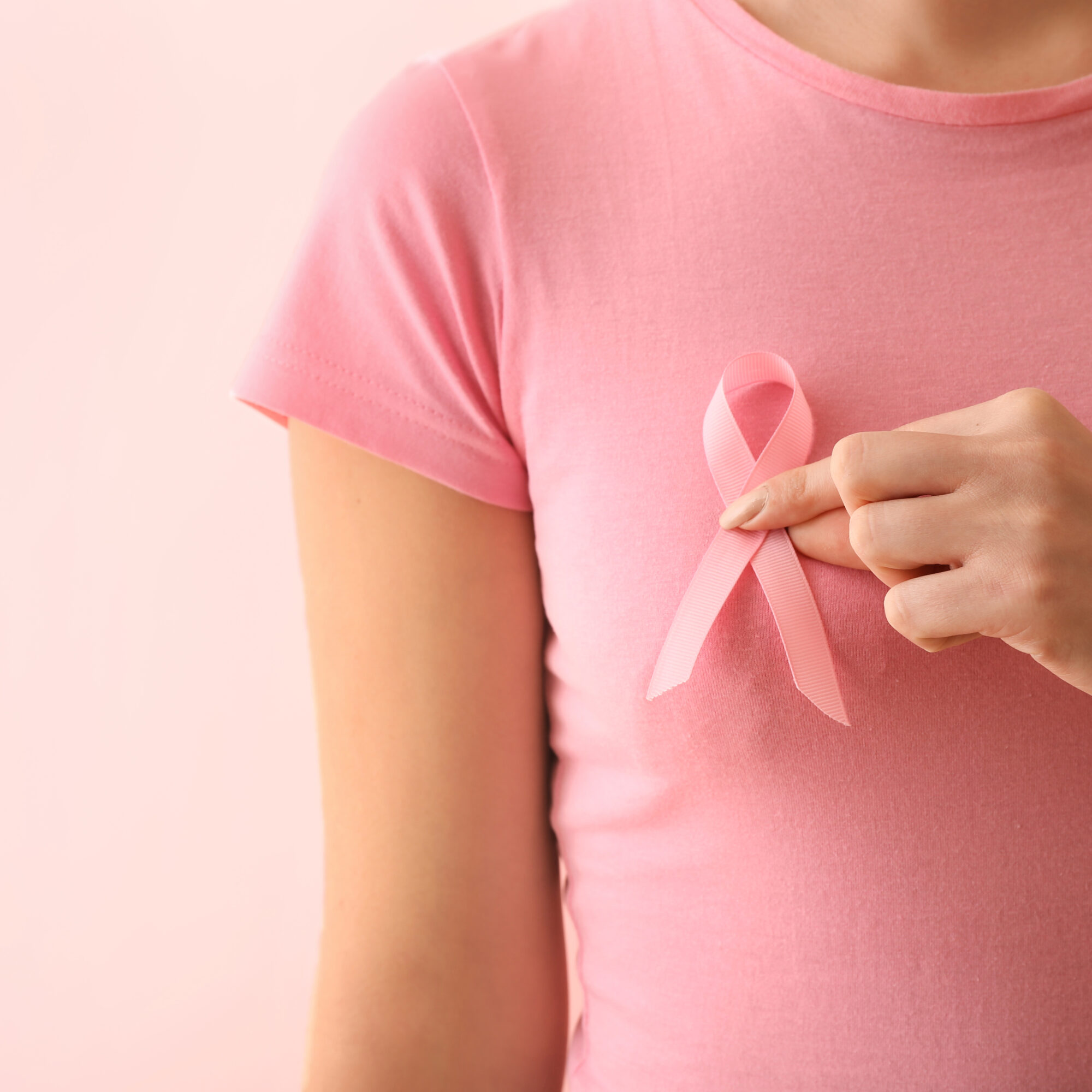 Woman with pink ribbon on color background. Breast cancer awaren